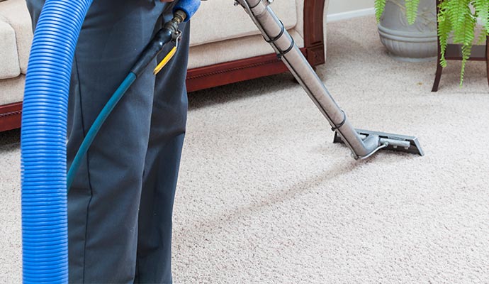 man holding blue pipe vacuam cleaning machine carpet cleaning