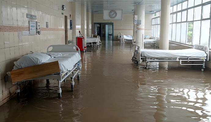 A flooded hospital ward with standing muddy water