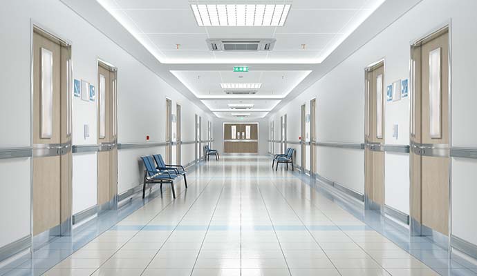 A long hospital hallway with tile surface
