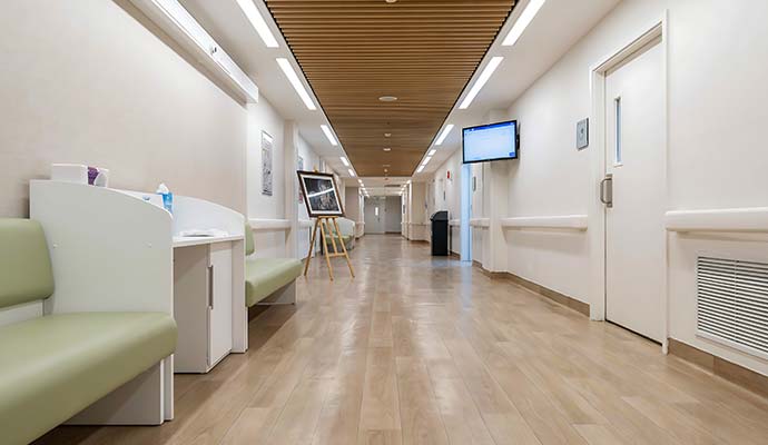 A long hospital hallway with wood floor