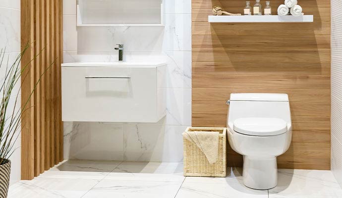 A modern clean bathroom featuring a white floating vanity and a contemporary white toilet