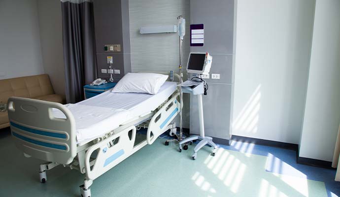 A modern hospital room featuring a clean patient bed