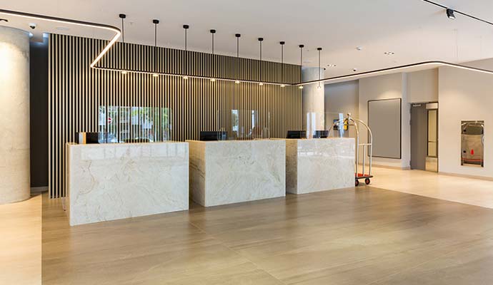 A modern hotel lobby reception area featuring clean wooden floor