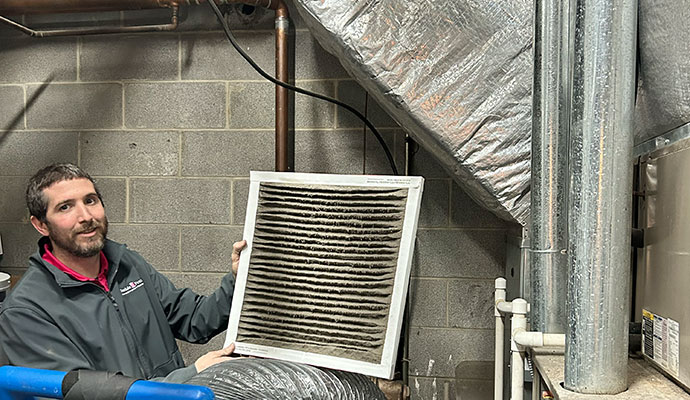 Technician holding a dirty HVAC air filter