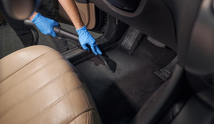 Professional worker cleaning a car interior