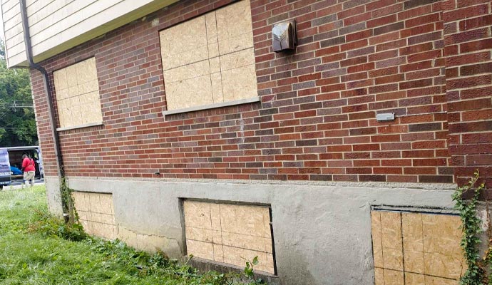 Plywood boards covering windows on a brick building