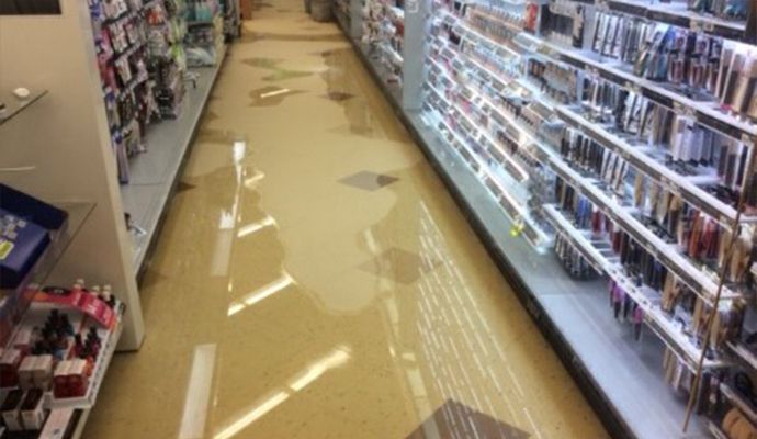 A long aisle in a retail store with highly polished, glossy granite floor