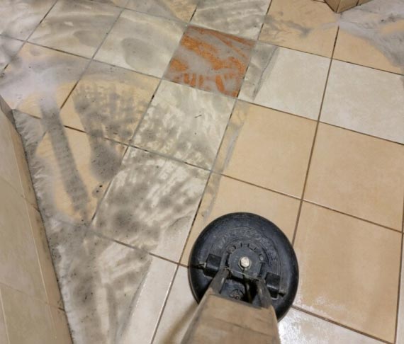 Expert worker cleaning floor with professional tools