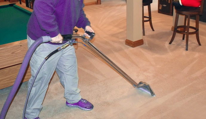 Person cleaning carpet with vacuum cleaner