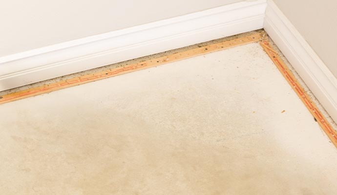 Carpet tack strips installed on a subfloor corner