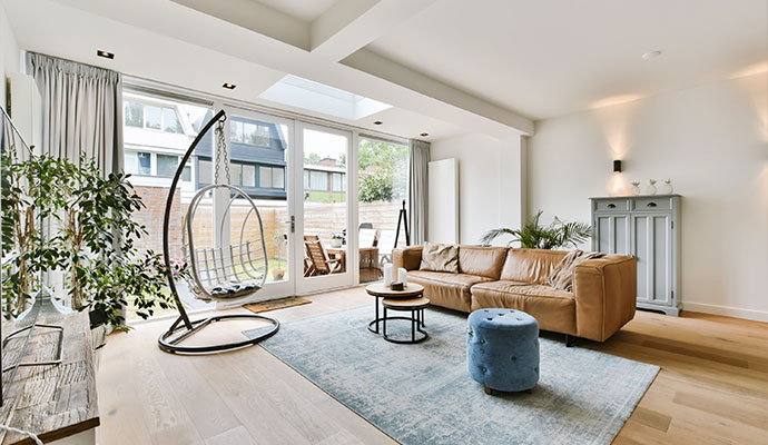 Clean, bright living room with a leather sofa and area rug after smoke odor removal service