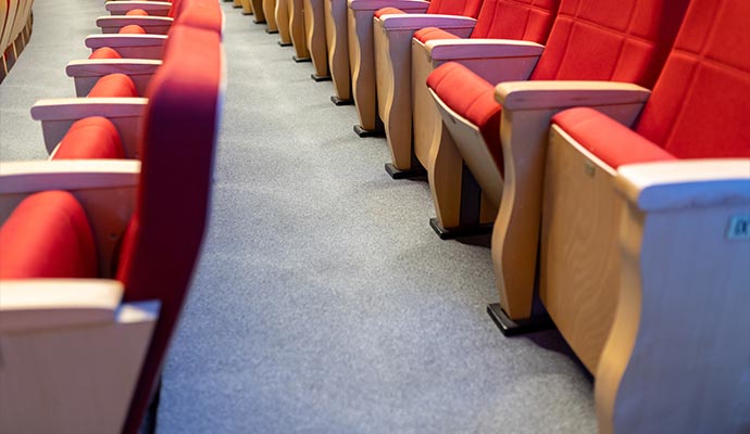 Clean commercial carpet between rows of theater seats