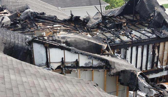 Charred wooden framing and collapsed roof from structural fire damage