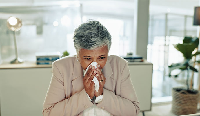A person reacting to allergens by covering their nose and mouth
