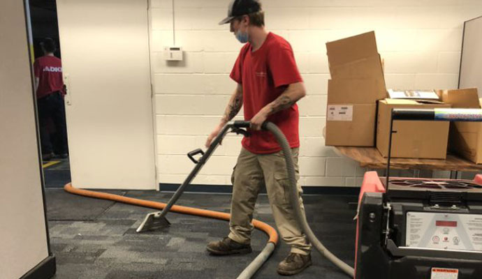 An expert cleaning office carpet using a vacuum cleaner