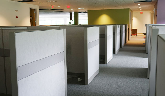 Row of light gray office cubicles in a modern workspace
