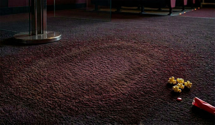 Faded discolored bleach spot on movie theater carpet