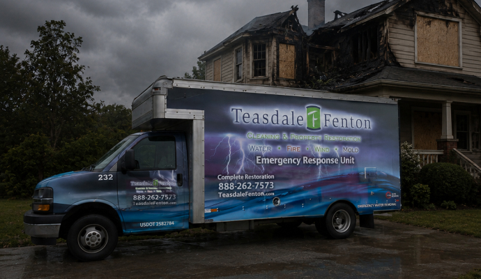 Teasdale Fenton service truck in front of fire damaged house