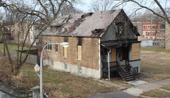 Fire damaged boarded-up residential house