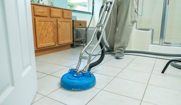 a person providing floor cleaning service to a bathroom