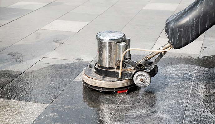 Professional technician polishing granite floors