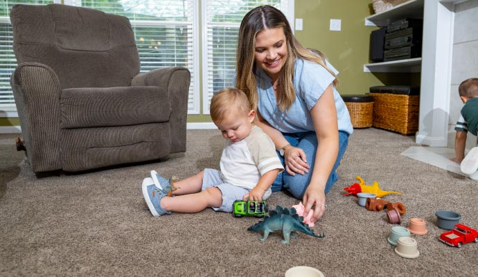 Mother and children playing on a clean carpet