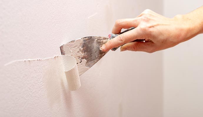 Worker removing wall painting