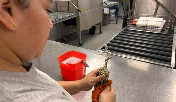 Restoration specialist cleaning trophy