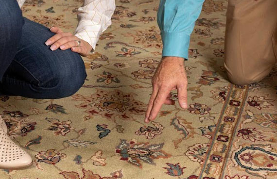 a couple of people inspecting a rug