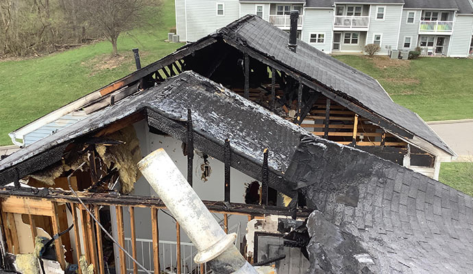 Residential property with extensive structural fire damage collapsed roofing and burned interior sections