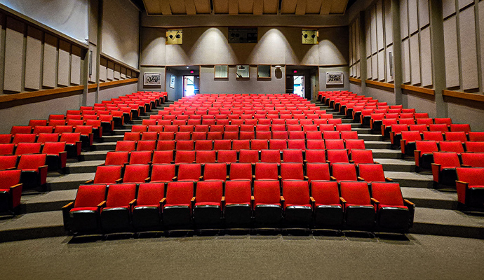 Spacious movie theater with clean seating and carpeted aisles