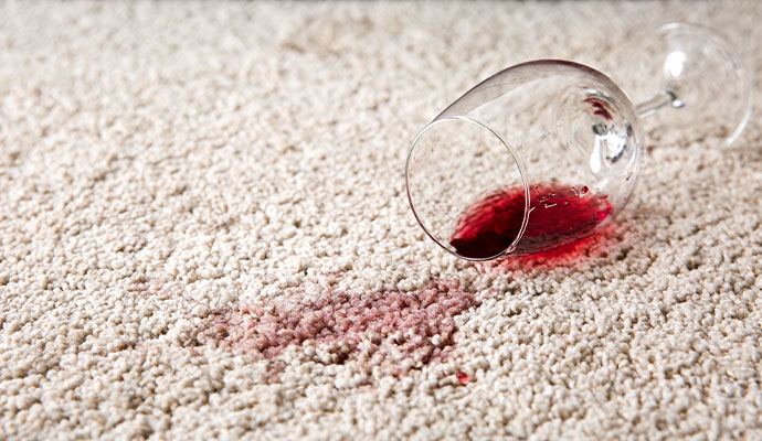 Spilled red drink creating a stain on carpet