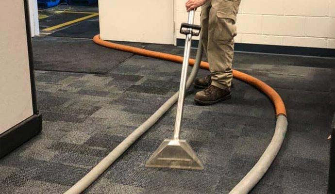Professional technician using portable carpet extraction machine