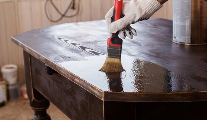 Applying stain on restored furniture