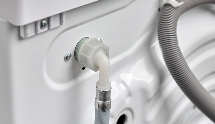 Close-up view of washing machine inlet hose connection