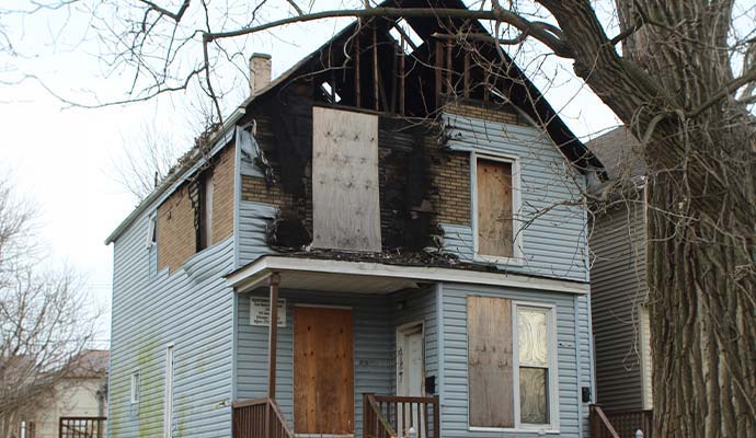Plywood boards installed on windows and doors of a fire damaged house.