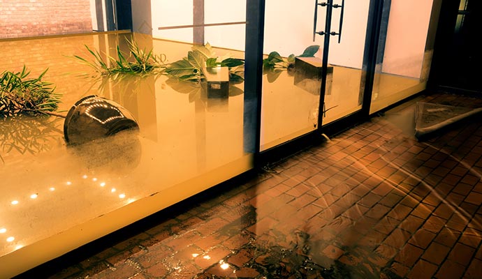 A commercial store completely flooded with murky brown water.