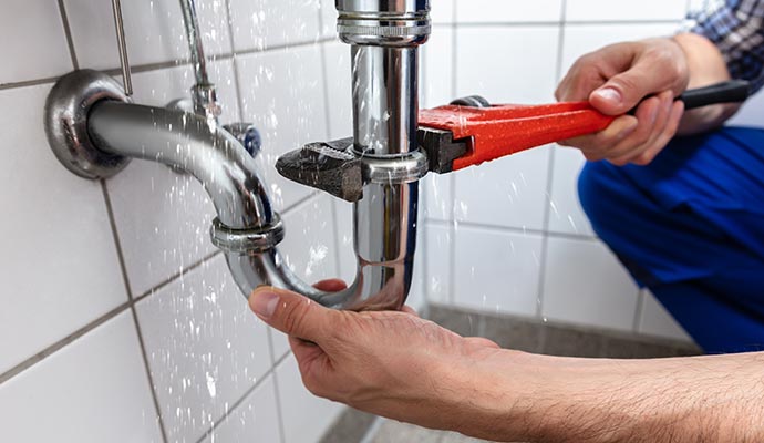 Professional worker repairing plumbing leak